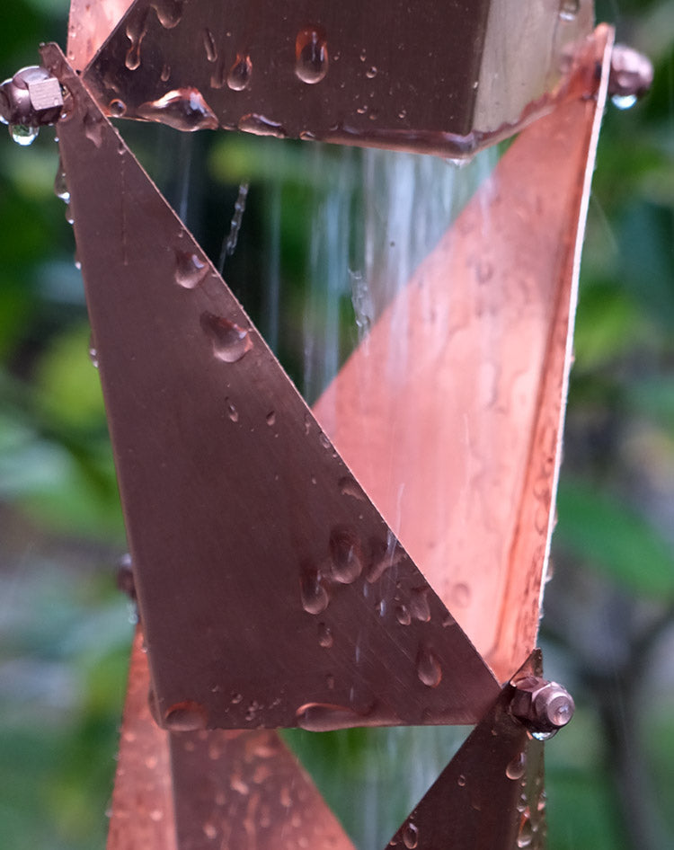 Copper Origami square-cup rain chain carrying water in heavy flow