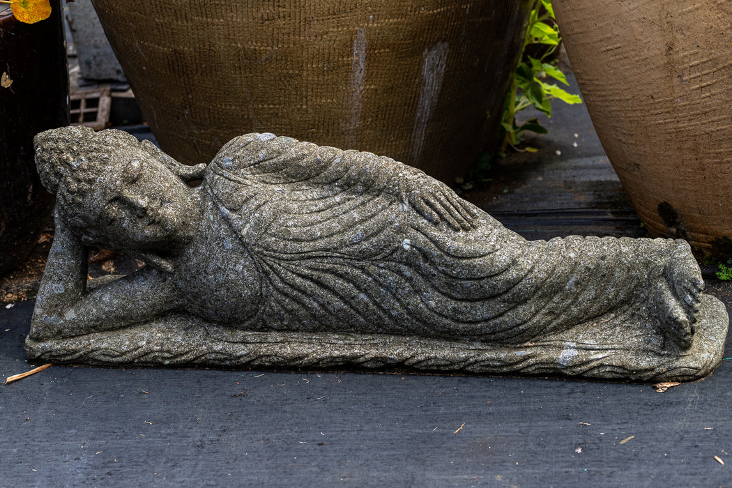 reclining buddha head on right arm draped robes hand carved stone statue 